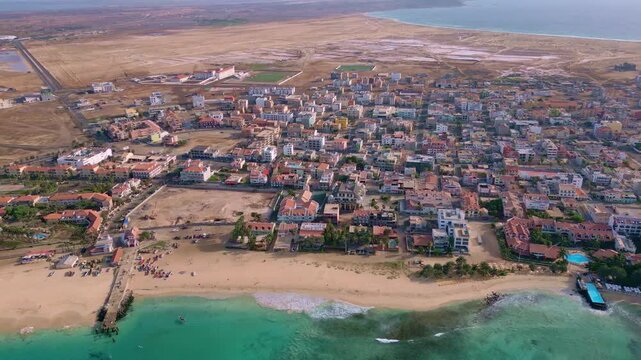 Cinematic drone footage of Santa Maria beach and pier, Sal Island, Cape Verde. Captured at golden hour with turquoise waters, fishing boats and tropical atmosphere in 4K  formats.