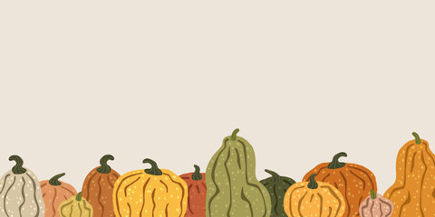 Colorful pumpkins forming a seamless border on a beige background © megis