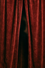 Red velvet curtain slightly parted with a shadowy human silhouette behind it, creating a mysterious and dramatic atmosphere.