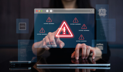 A person interacting with a laptop displaying system warning alerts, emphasizing concerns related to data security and technology.