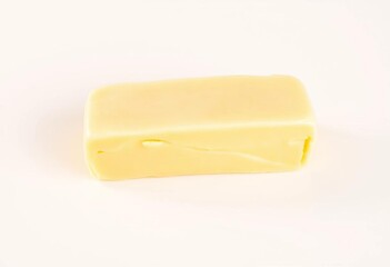 Soft, pale yellow butter pat on a creamy white background,  photography,  spread