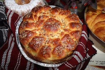 Freshly baked homemade bread arranged in traditional Bulgarian textiles. Image of some tasty Home-made bakery products. Fresh bread,brown, wheat, sliced, round, product, bagel, delicious, baking.