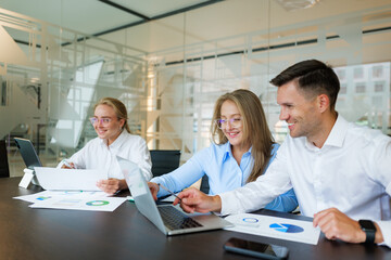 Obraz premium Collaborative teamwork in a modern office as professionals analyze data and prepare reports