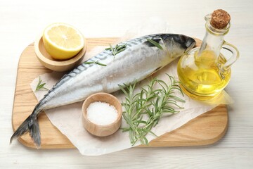 Fresh raw mackerel and spices on light wooden table, above view. Seafood delicacies