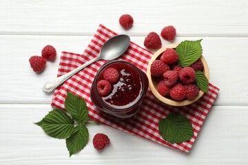 Tasty jam, fresh ripe raspberries and leaves on white wooden table, flat lay.