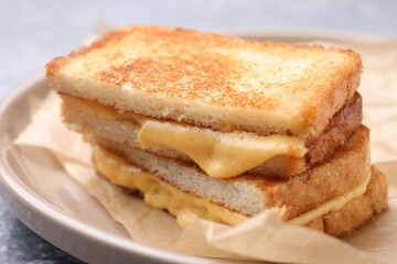 Tasty sandwiches with melted cheese and parsley on table, closeup