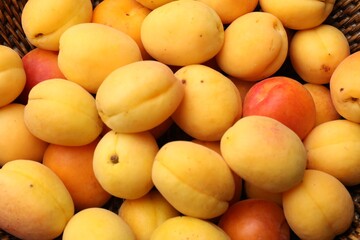 Fresh ripe apricots in wicker basket, top view