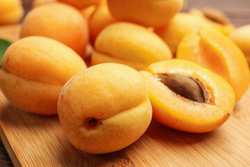 Yummy ripe apricots on wooden board, closeup