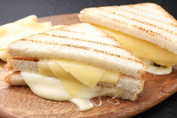 Tasty sandwiches with melted cheese on table, closeup