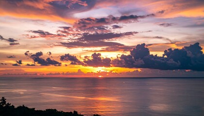 A breathtaking sunset paints the vast ocean with vibrant hues of orange, purple, and pink, showcasing dramatic clouds against the horizon.