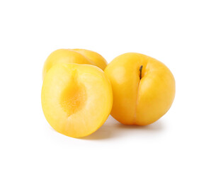 Whole and cut yellow cherry plums isolated on white