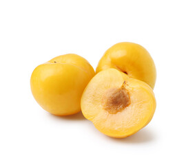 Whole and cut yellow cherry plums isolated on white