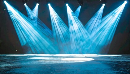 A dramatic stage setting illuminated by intense spotlights, casting a vibrant blue glow.
