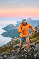 Fototapeta premium Man athlete trail running in sunset mountains travel in Norway active adventure vacations, male traveler hiking solo healthy lifestyle extreme trip fitness endurance motivation