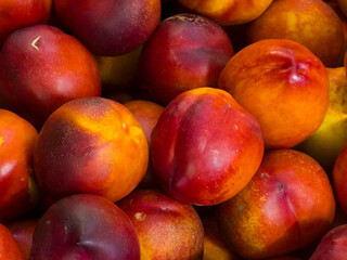 Fresh ripe nectarines piled together in a close-up food background