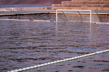 Outdoor water polo pool in Biograd na Moru, Croatia, with floating goal and calm water reflecting...