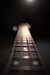 Close-up of guitar neck illuminated by soft light, highlighting