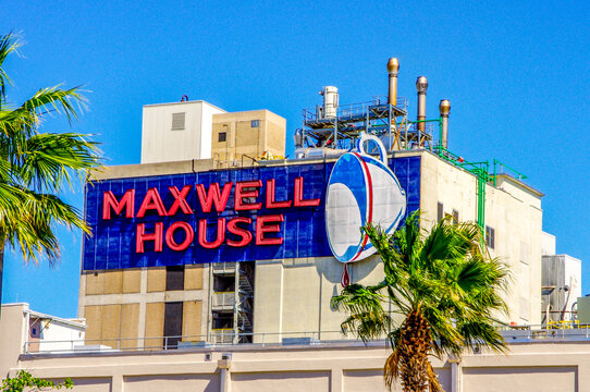Jacksonville, FL&mdash;March 19, 2019; blue and red sign with white cup dripping coffee marketing Maxwell House brand displayed on outside of roasting facility.