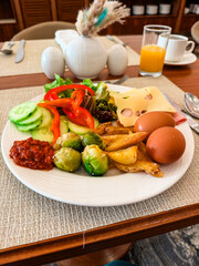 A breakfast plate with eggs, cheese, vegetables and potatoes on a restaurant table. Nutrition, balance, energy and morning wellness in a hotel dining atmosphere.