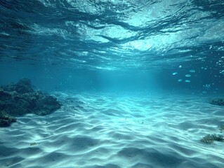 Underwater scene of sandy seabed with sunlight filtering through water surface in tropical location
