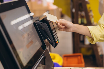Customer Paying with Contactless Credit Card at Supermarket Checkout