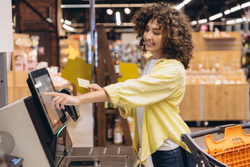 Customer Paying Using Self Checkout Kiosk in Supermarket