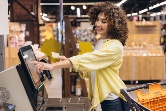 Customer Paying Using Self Checkout Kiosk in Supermarket - Powered by Adobe