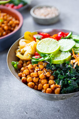 Buddha bowl - vegetarian bowl with chickpeas and fresh vegetables on the table vertical photo