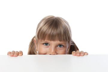 Curious little girl peeking over table against white background