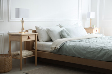 Bedside tables with lamps near bed indoors