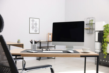 Stylish workplace with modern computer and stationery on wooden table in office