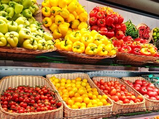 Supermarket fruit refrigerated section. Food retail in grocery store. fresh vegetables, peppers, tomatoes.