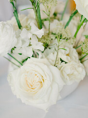 Elegant white floral arrangement featuring roses and delicate blooms for a serene decor