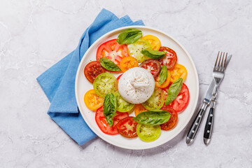 Fresh burrata served on slices of colorful tomatoes
