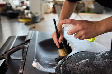 The thorough and effective cleaning process of a car part involves foam and a brush technique