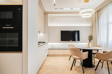 Modern kitchen and dining area featuring stylish design elements with ample natural light in a contemporary home