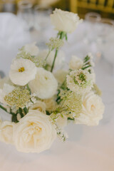 Elegant white floral arrangement enhances the atmosphere of a special event setting in soft lighting