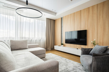 Modern living room design featuring a cozy sofa, sleek furniture, and large windows with natural light in a stylish interior