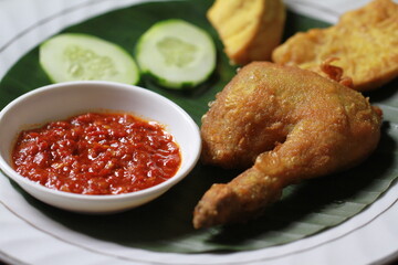 Indonesian fried chicken with sambal red chili, tofu,cucumber and tempe
