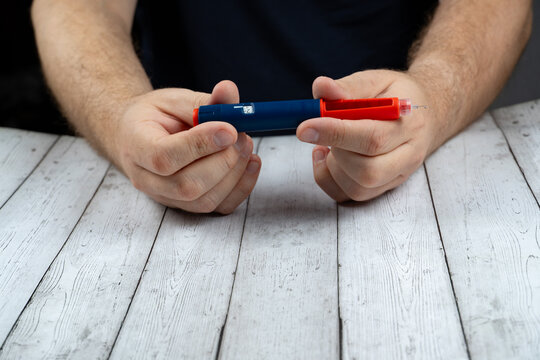 Ozempic Insulin injection pen or insulin cartridge pen for diabetics. Man holding an injection pen for diabetic. Concept weight loss injection.