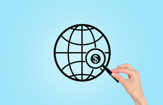 A hand is pointing at a globe with a dollar sign on it