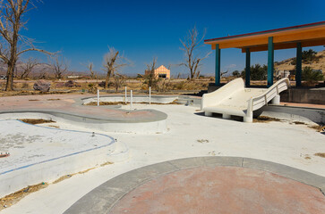 Fototapeta premium Dry Waterslide and Desert Landscape at Abandoned Rock-A-Hoola Waterpark in California