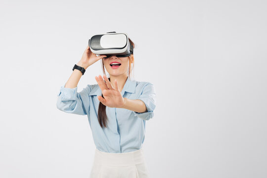 Asian woman in vr headset glasses touches virtual game future, enjoying vr experience, hand gesture controls online application, businesswoman interacts with screen, isolated studio white background