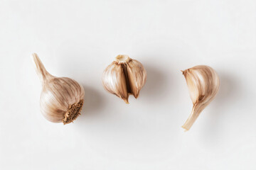 three heads of garlic on a white surface