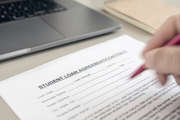 Obraz premium Human hand filling a Student Loan form on desk