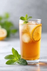 Fototapeta premium Refreshing iced tea with lemon and mint on a marble surface in bright light