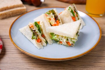 Homemade sandwich with mayonnaise and salad filling in ceramic plate