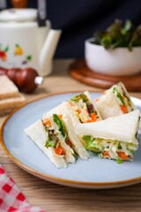 Homemade sandwich with mayonnaise and salad filling in ceramic plate
