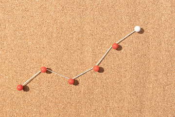 Minimalist up chart made of pushpins pinned on cork board. Growing concept