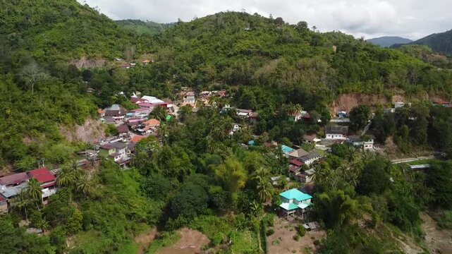 Aerial drone forward shot approaching Pak Beng village in Laos with tilt down